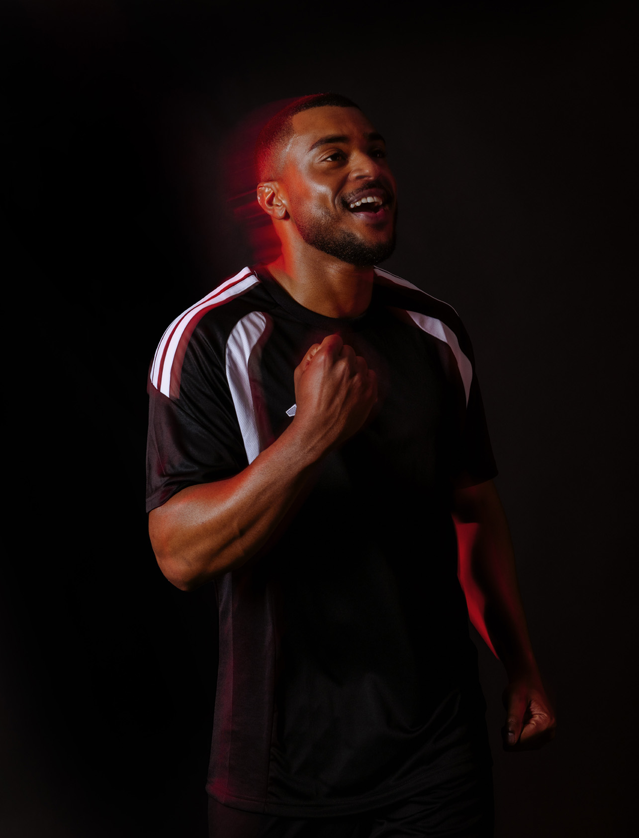 Football athlete with red light streaks, studio